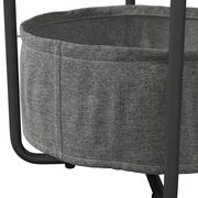 Nahaufnahme eines grauen Beistelltisches mit Stoffkorb und schwarzen Metallbeinen, seitliche Perspektive.