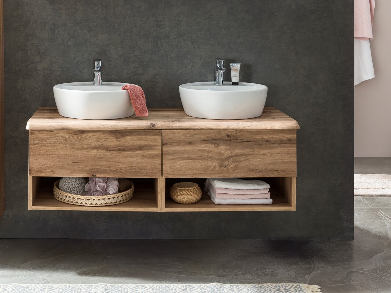 Moderne wastafelcombinatie met twee ronde wasbakken op een houten blad, gefotografeerd van voren.