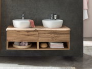 Moderne wastafelcombinatie met twee ronde wasbakken op een houten blad, gefotografeerd van voren.