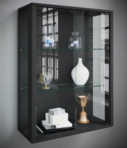 Schwarze Glasvitrine mit Glasböden und zwei Glastüren, bestückt mit Deko (Vase, Uhr, Pokal, Geschenkboxen), in schräger Frontansicht von links.
