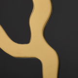 Nahaufnahme eines goldenen, geschwungenen Details auf schwarzem Hintergrund, perspektivisch von der Seite betrachtet.