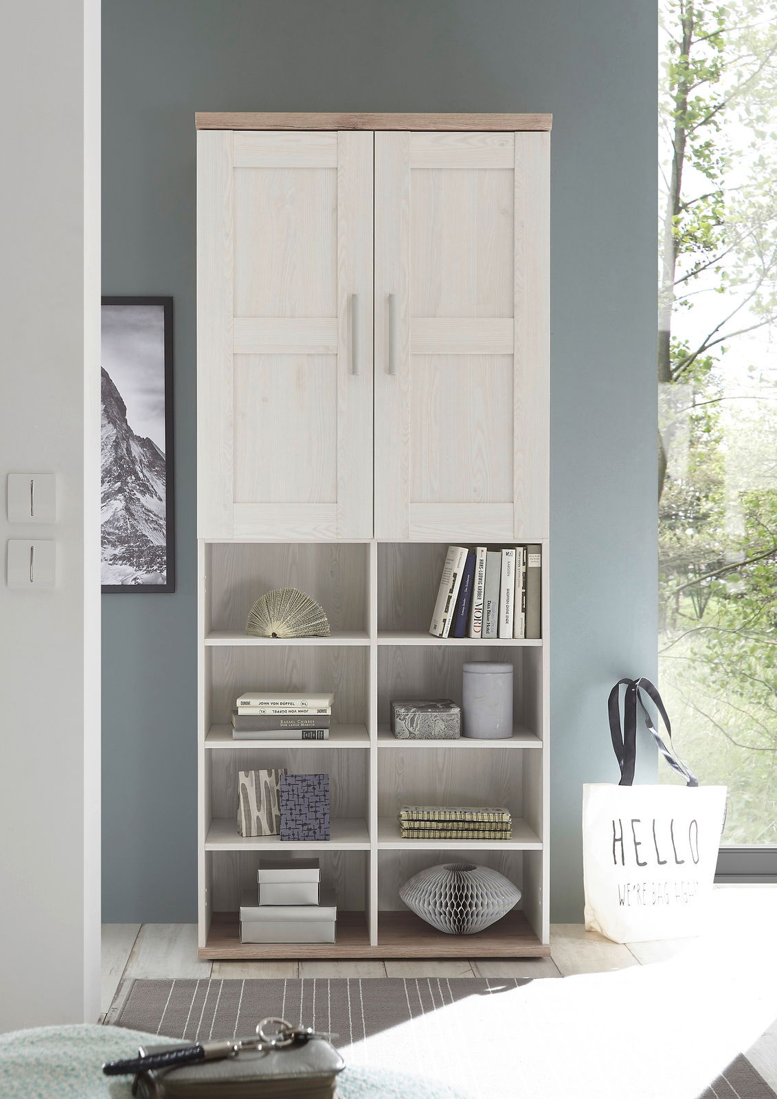 Mehrzweckschrank in heller Holzoptik mit zwei Türen oben und offenen Regalfächern unten, frontal fotografiert.