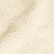 Nahaufnahme eines elfenbeinfarbenen Handtuchs mit weicher Textur.