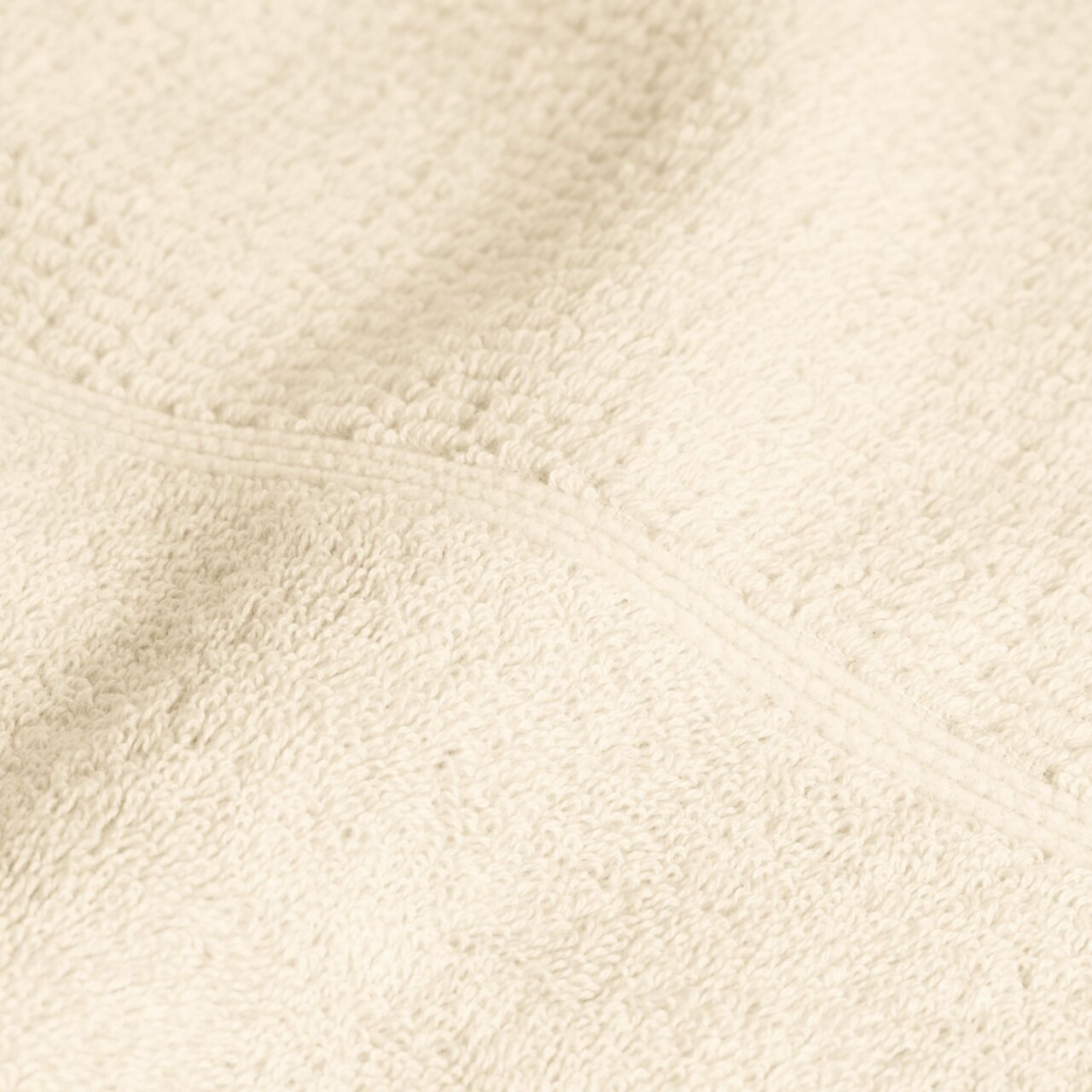 Nahaufnahme eines elfenbeinfarbenen Handtuchs mit weicher Textur.