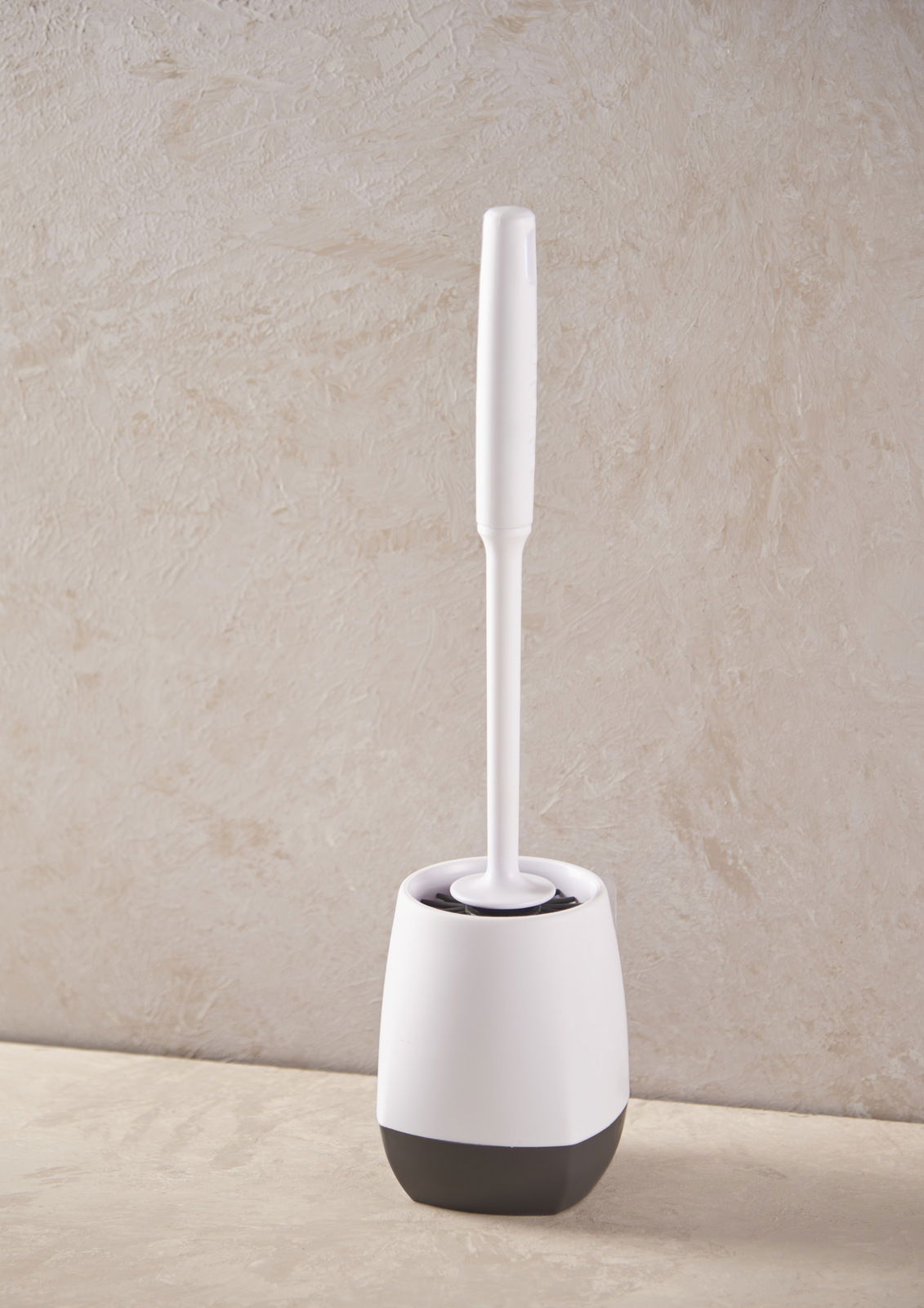 Toilettenbürste in einem weißen und schwarzen Halter, seitliche Perspektive