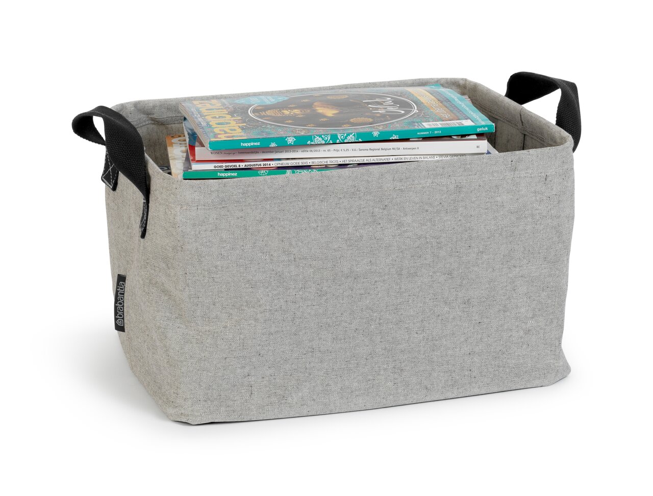 Grijze, opvouwbare wasmand met zwarte handvatten, gevuld met tijdschriften, gezien vanaf de zijkant.