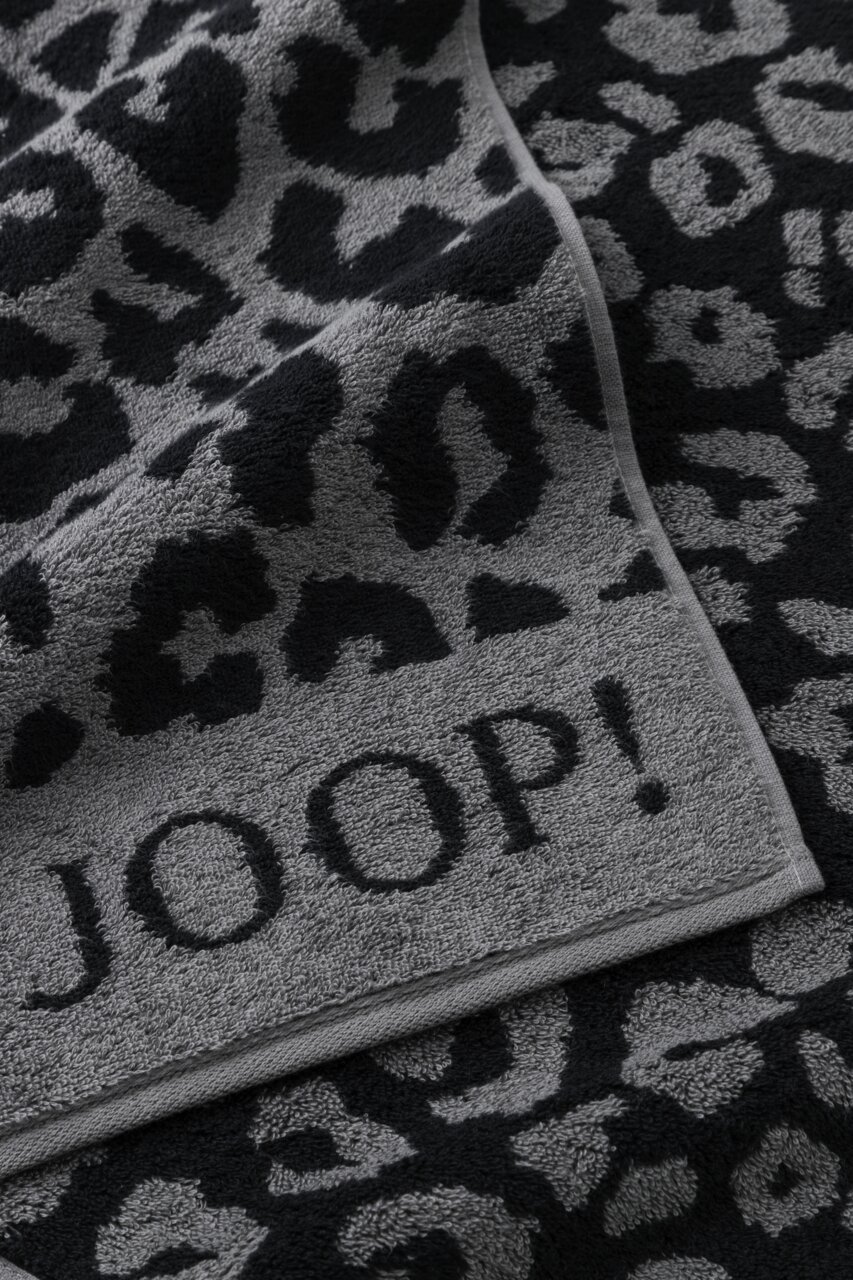 Graues Handtuch mit schwarzem Leopardenmuster und dem Schriftzug 'JOOP!' in Nahaufnahme.