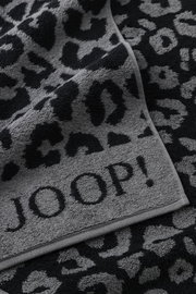 Graues Handtuch mit schwarzem Leopardenmuster und dem Schriftzug 'JOOP!' in Nahaufnahme.