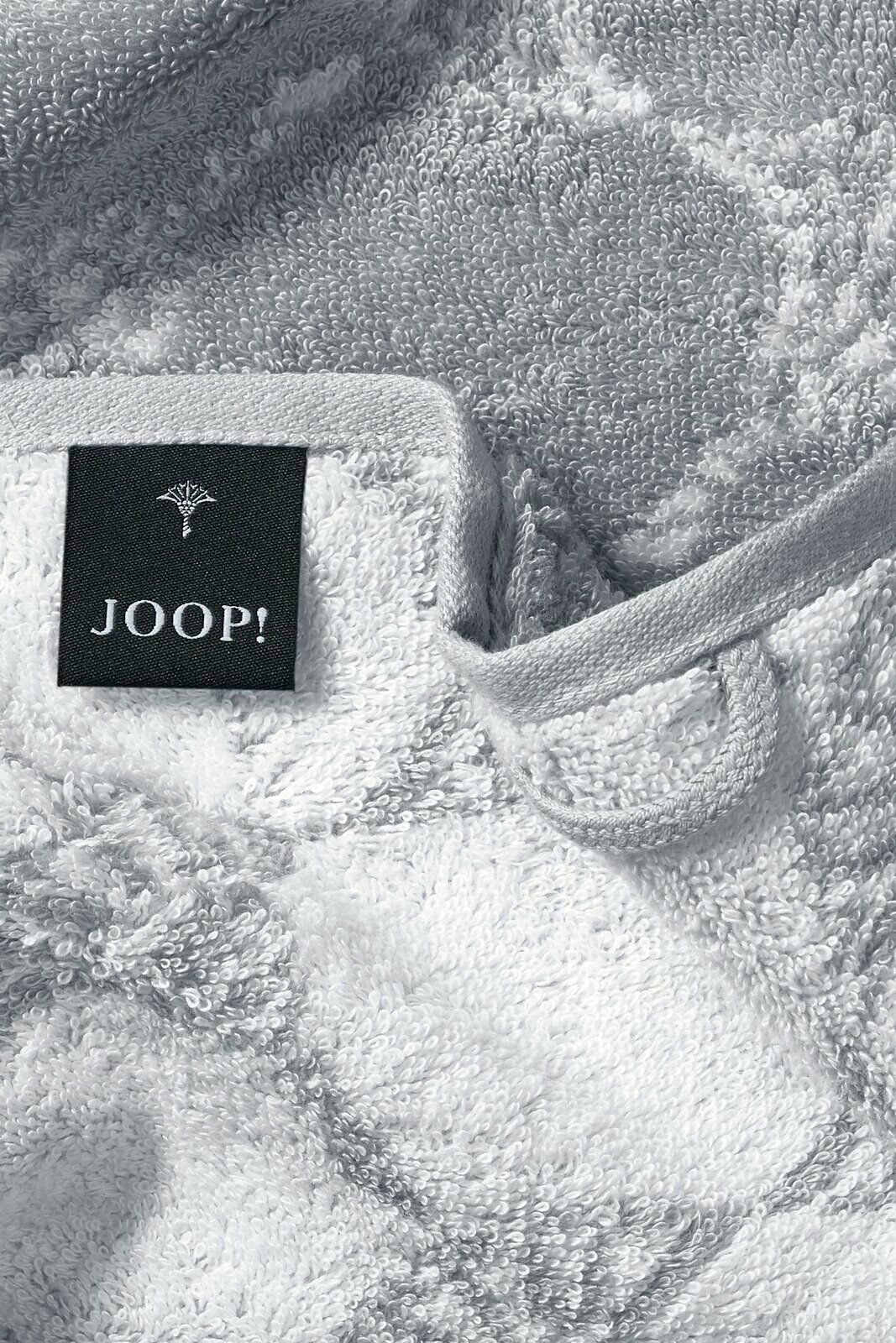Nahaufnahme eines weichen, grauen Gästetuchs mit einem schwarzen Etikett, auf dem 'JOOP!' steht.