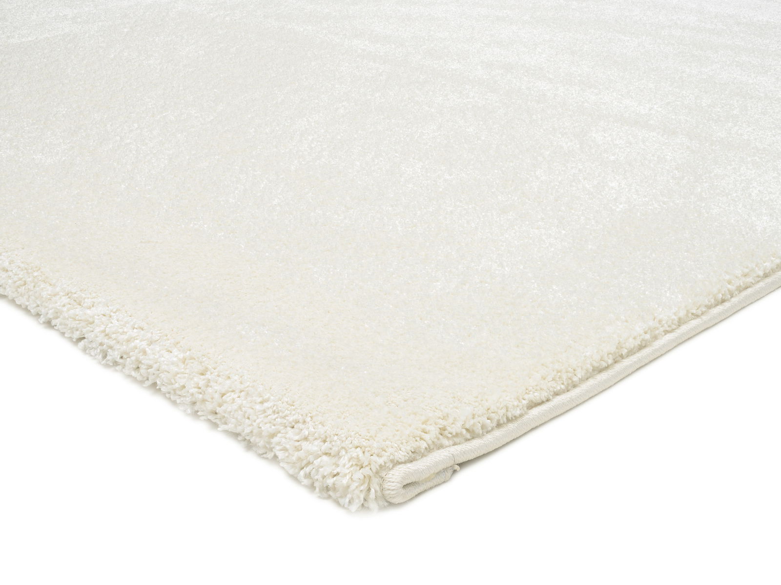 Nahaufnahme eines weißen Uni-Teppichs mit weicher Textur, von der Seite fotografiert.