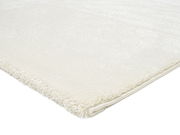 Nahaufnahme eines weißen Uni-Teppichs mit weicher Textur, von der Seite fotografiert.