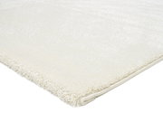 Nahaufnahme eines weißen Uni-Teppichs mit weicher Textur, von der Seite fotografiert.