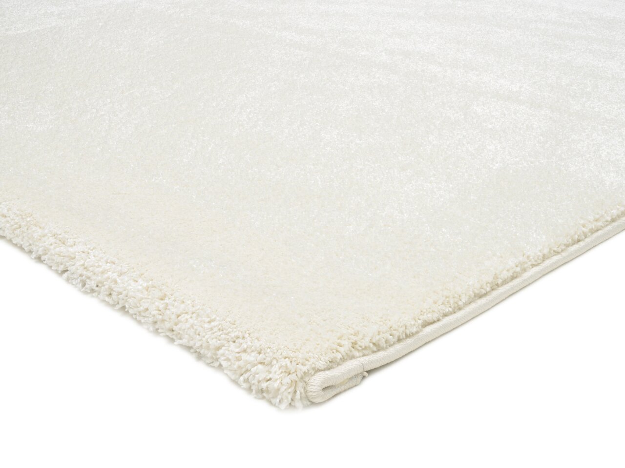 Nahaufnahme eines weißen Uni-Teppichs mit weicher Textur, von der Seite fotografiert.