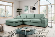 Mintgrünes L-förmiges Ecksofa mit Ottomane links und drei Sitzkissen in modernem Wohnzimmer, fotografiert in frontaler leicht schräger Perspektive.