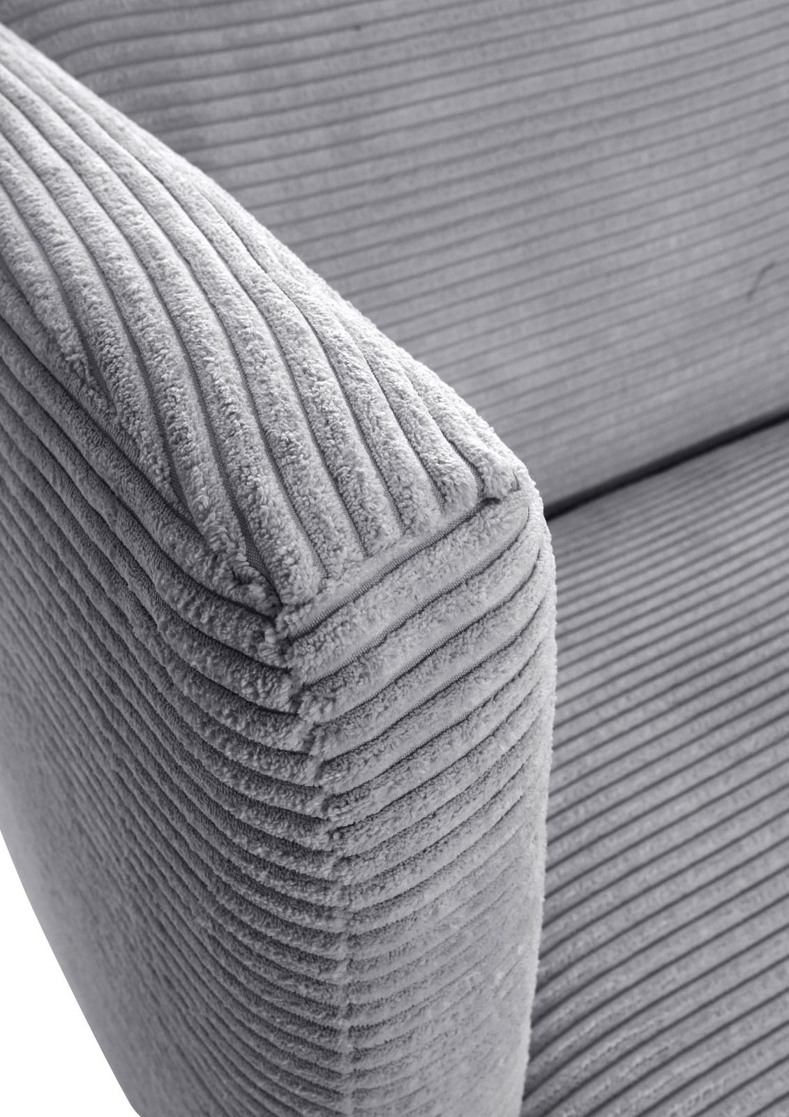 Nahaufnahme eines grauen, gerippten Sofas mit Armlehne, seitliche Perspektive