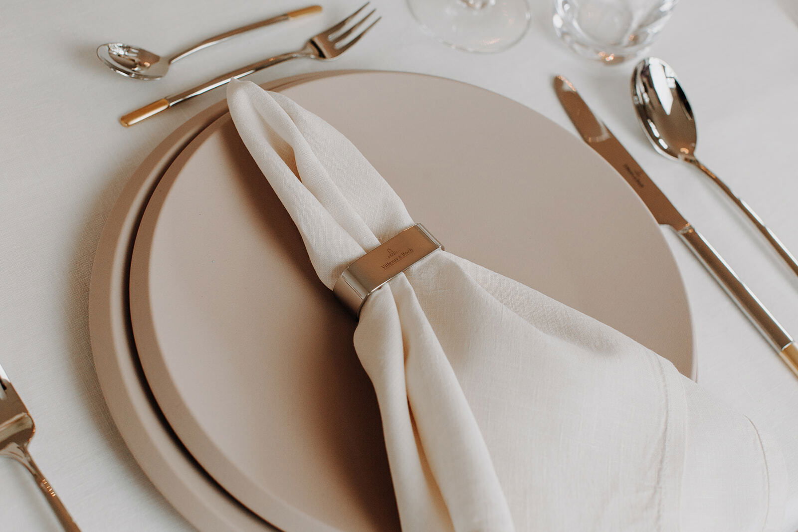 Eleganter Speiseteller NewMoon 29cm in einer Tischdekoration mit Besteck und Serviette, aus der Vogelperspektive.