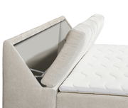 Nahaufnahme eines Boxspringbetts mit geöffnetem Stauraum im Kopfteil, seitliche Perspektive