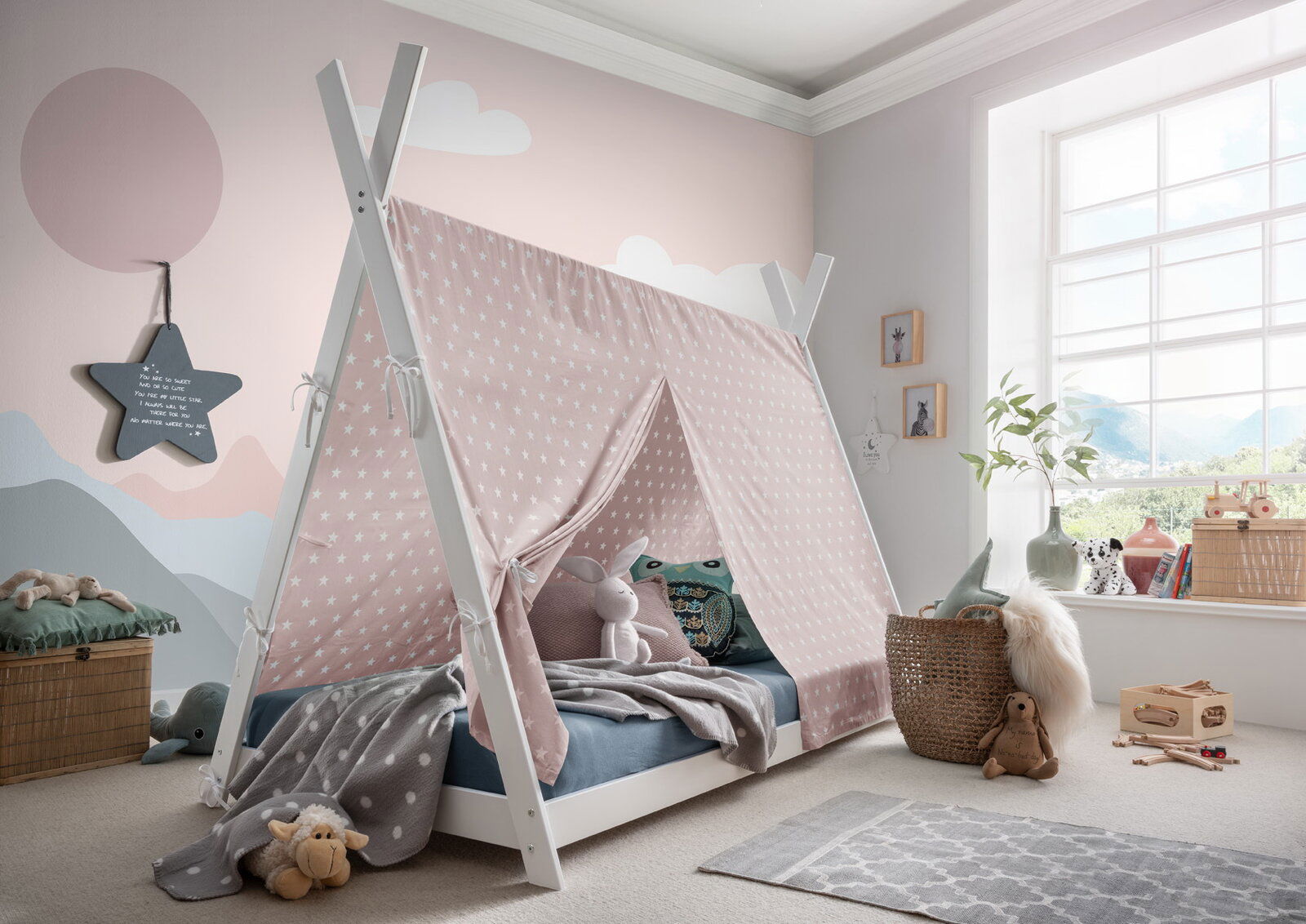 Kinderzimmer mit einem Stoffdach in Zeltform über einem Bett, dekoriert mit Kuscheltieren und Decken, seitliche Perspektive