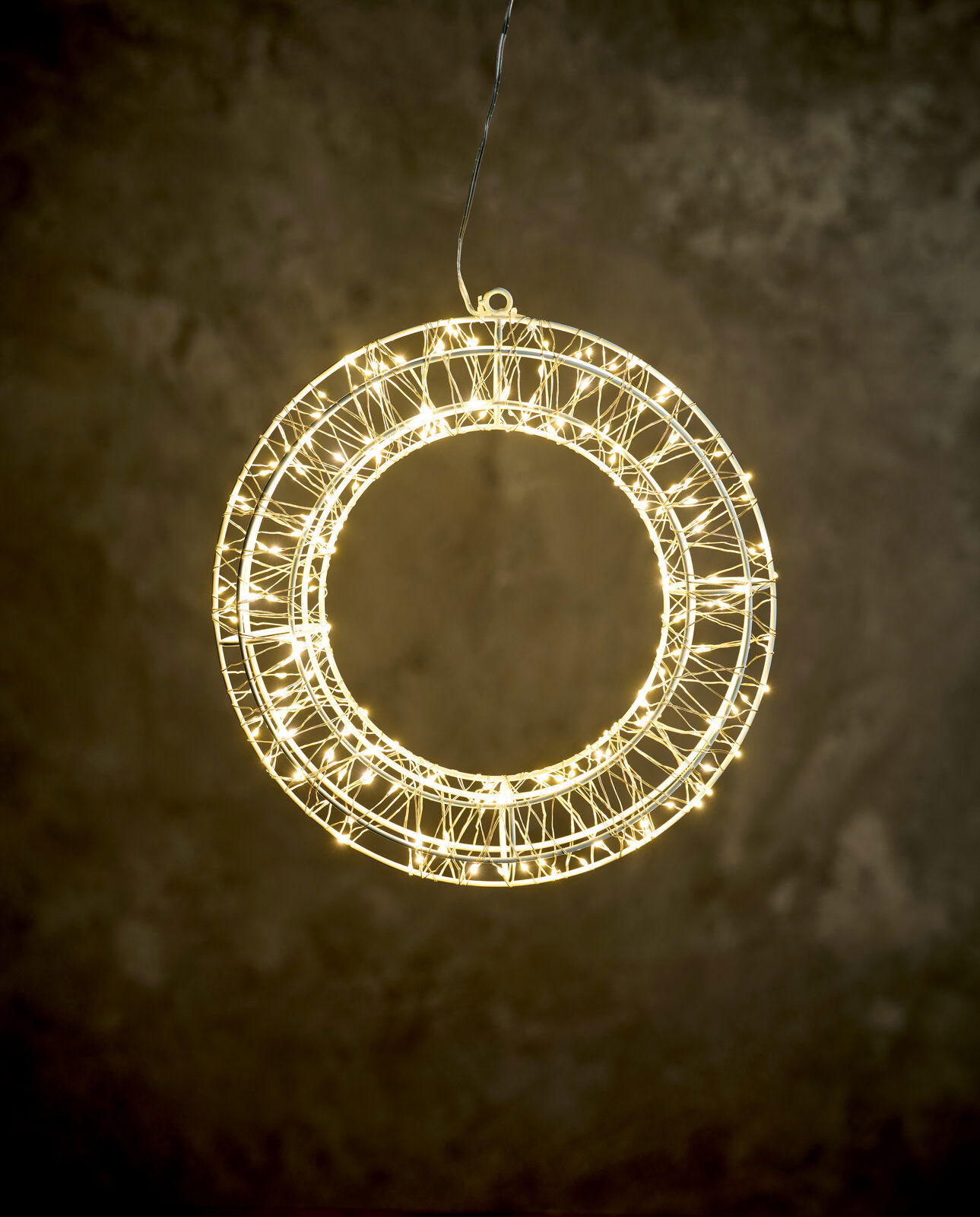 Day LED-Kranz Ø30cm mit 200 LED``s Leuchtender LED-Kranz mit 30 cm Durchmesser, frontal betrachtet, vor einem dunklen Hintergrund hängend.