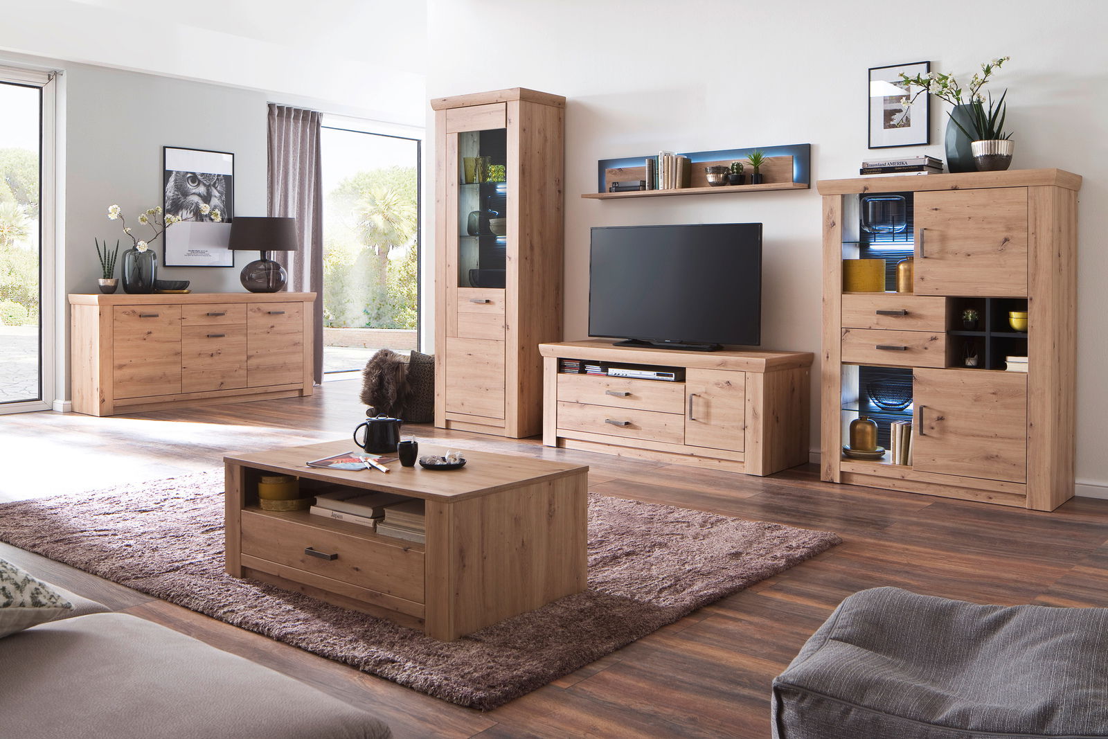 Wohnzimmer mit modernem Sideboard aus Holz in natürlicher Optik, frontal betrachtet, umgeben von weiteren Möbelstücken im gleichen Stil.