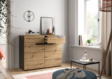 Moderne Kommode aus Holz mit Schubladen, seitliche Perspektive, dekoriert mit Büchern und Vasen, in einem hellen Raum mit Fenster.
