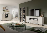 Modernes Wohnzimmer-Set mit hellen Sideboards und hohen Regalen vor olivgrüner Akzentwand, TV auf Lowboard, runde Couchtische auf Teppich; Perspektive: frontale Weitwinkelansicht aus leicht erhöhter Augenhöhe.