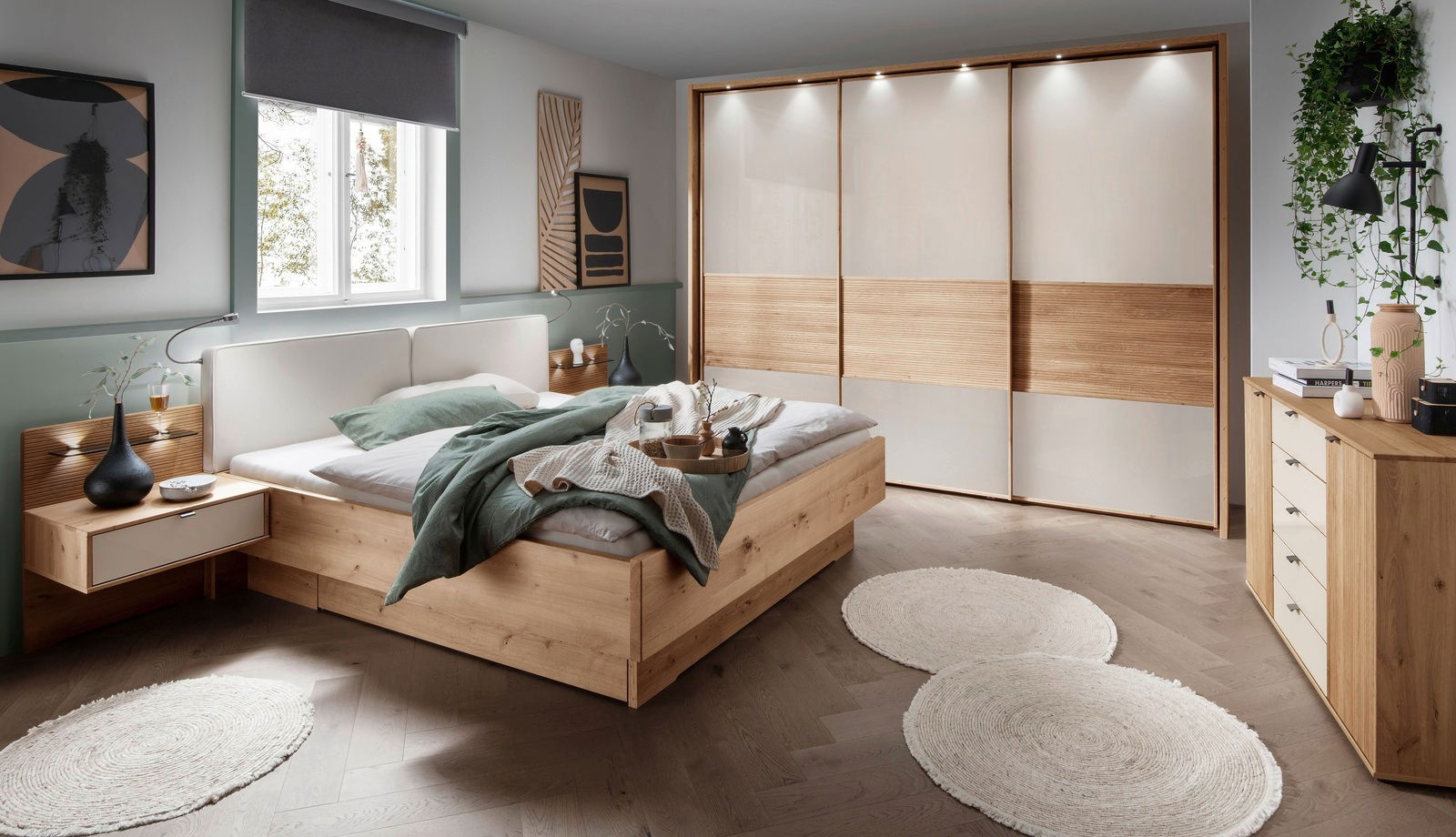 Moderner Schwebetürenschrank mit drei Türen in einem stilvollen Schlafzimmer, aus hellem Holz und weißen Paneelen, mit integrierter Beleuchtung. Perspektive: Frontalansicht.