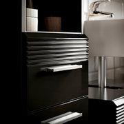 Nahaufnahme eines modernen schwarzen Hochschranks mit glänzenden Griffen und geriffelter Oberfläche, seitliche Perspektive