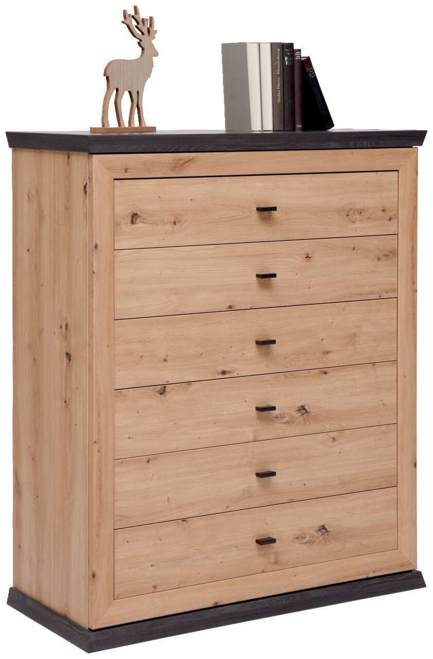 Hom´in Kommode BENTON Kommode aus hellem Holz mit fünf Schubladen, schwarzer Oberseite und Sockel, seitliche Perspektive. Dekoriert mit einem Holzrentier und Büchern.