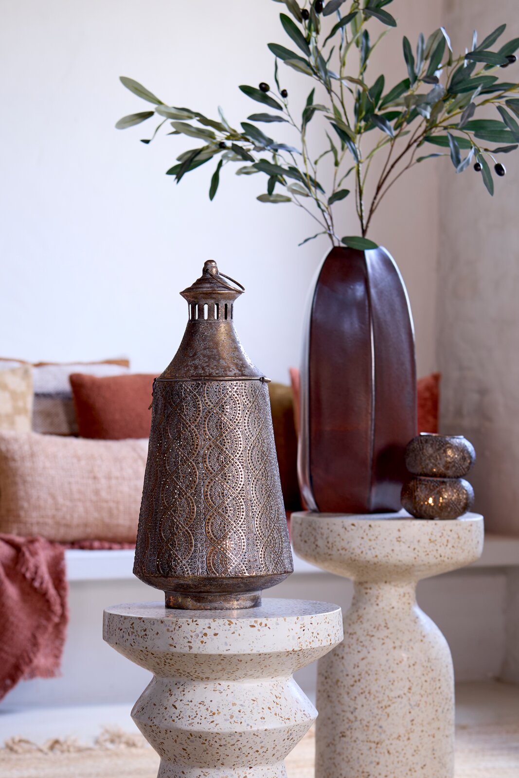 Metalen windlicht met filigraanpatroon, op een decoratieve tafel, zijaanzicht