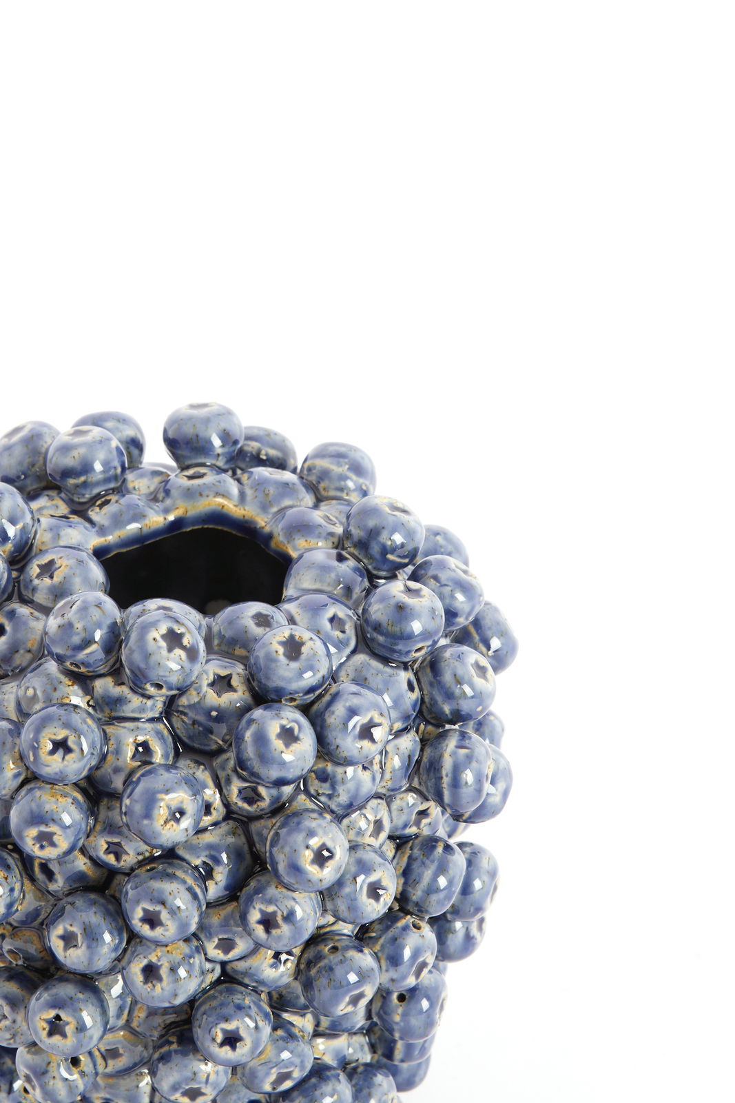 Nahaufnahme einer blauen Vase mit kugelförmigen Erhebungen, von oben betrachtet.