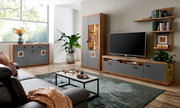 Moderne woonkamerwandcombinatie in houtlook met grijze fronten, bestaande uit een tv-meubel, vitrinekast en boekenkast, gezien vanaf de zijkant.