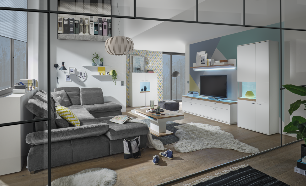 Set one by Musterring Vitrine Glasausschnitt links SET ONE LANCASTER Moderne Wohnzimmeransicht mit grauem Sofa, Couchtisch und TV-Lowboard in einem stilvollen, hellen Raum.