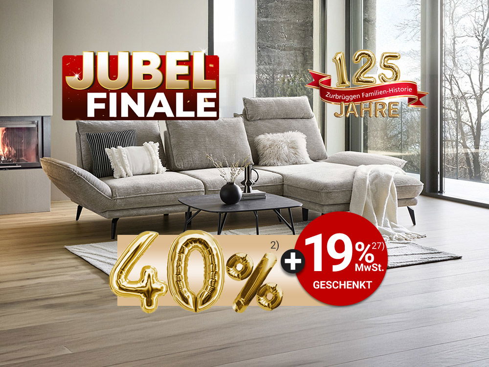 Modernes Wohnzimmer mit hellem Sofa vor Panoramafenstern, Kaminfeuer und Jubiläumsbanner „125 Jahre – Jubel Finale