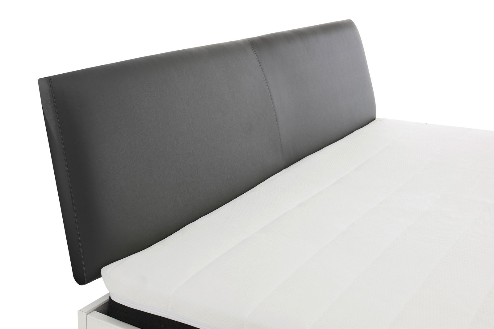 Nahaufnahme eines Bettgestells mit schwarzem Kopfteil und weißer Matratze, seitliche Perspektive