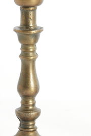 Nahaufnahme eines antik wirkenden, metallischen Lampenfußes mit gedrechseltem Design in seitlicher Perspektive.