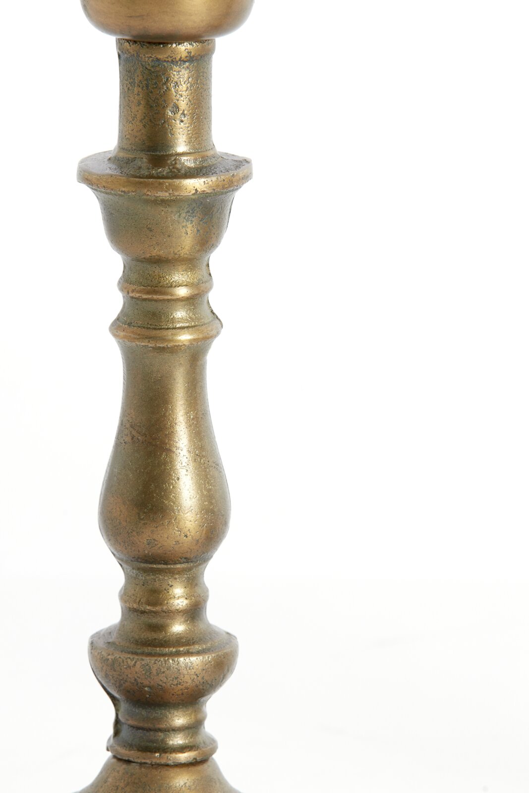 Nahaufnahme eines antik wirkenden, metallischen Lampenfußes mit gedrechseltem Design in seitlicher Perspektive.