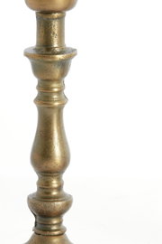 Nahaufnahme eines antik wirkenden, metallischen Lampenfußes mit gedrechseltem Design in seitlicher Perspektive.