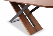 Nahaufnahme eines Esstisches mit einer modernen X-förmigen Tischbein-Konstruktion aus Holz und Metall, seitliche Perspektive.