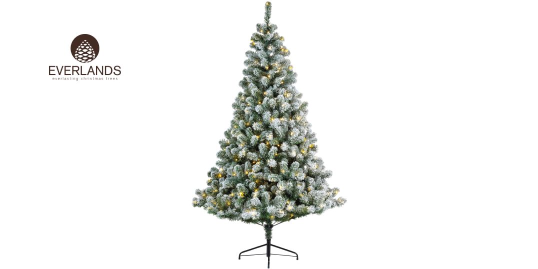 Ein wunderschön gefrosteter künstlicher Weihnachtsbaum, geschmückt mit zarten gelben Lichtern.