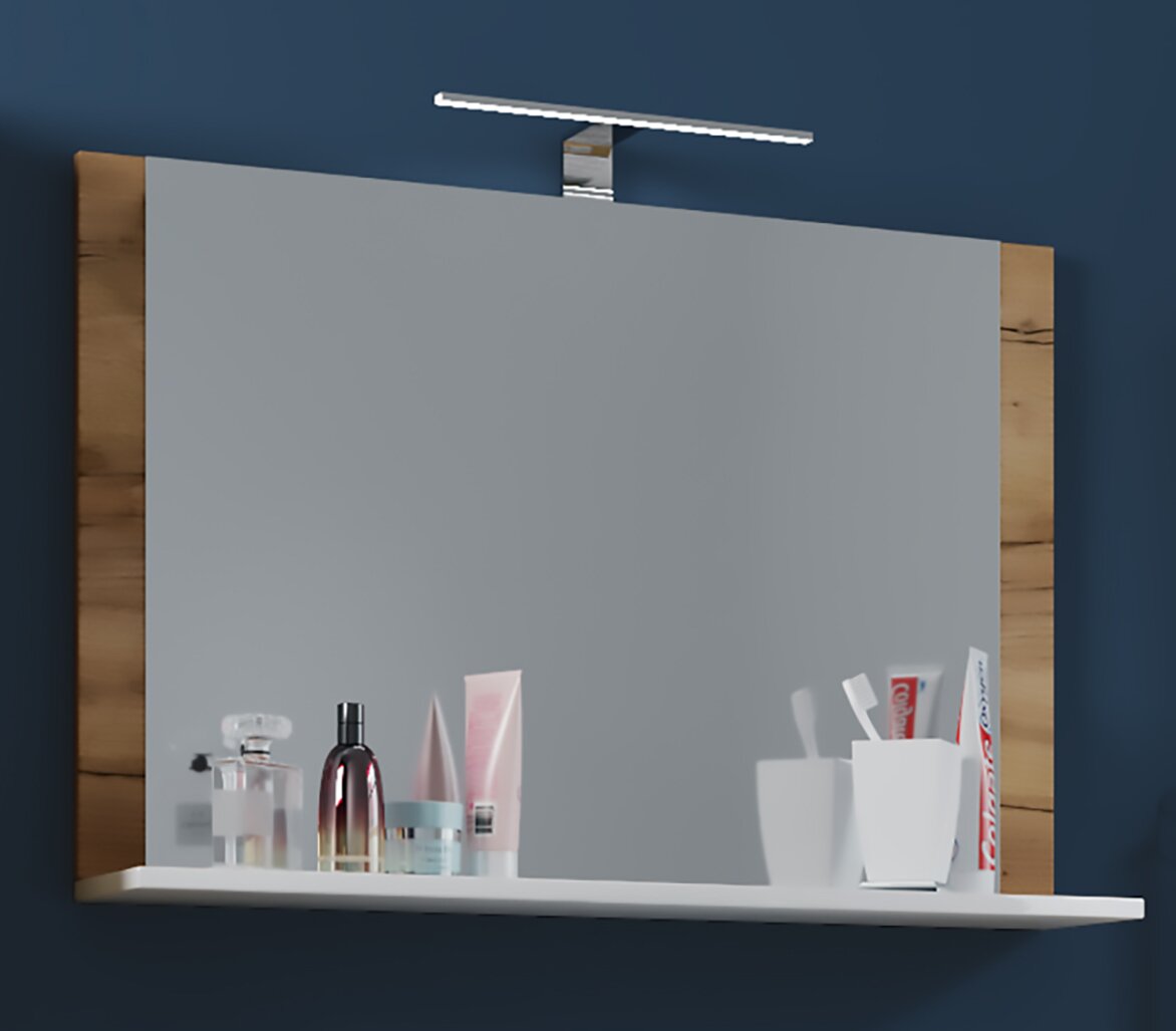 Moderner Badezimmerspiegel mit Holzrahmen, integrierter LED-Aufsatzleuchte und weißer Ablage mit Pflegeprodukten, frontale Ansicht leicht von links.