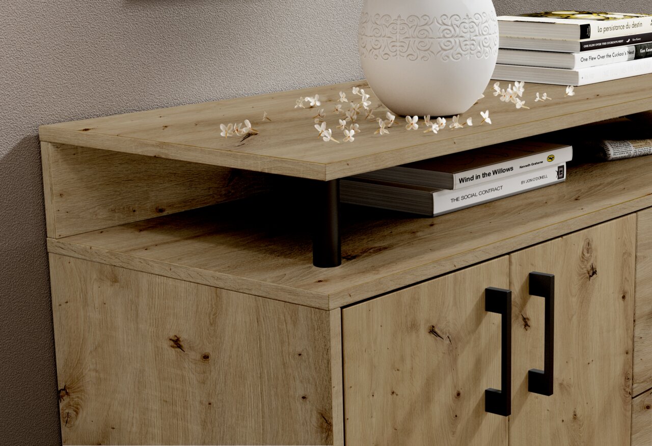 Close-up van een houten dressoir met twee deuren en zwarte handgrepen, versierd met boeken en een vaas, gezien vanuit de zijkant.