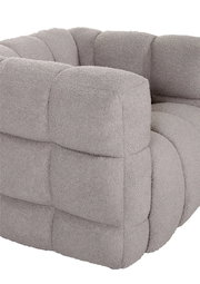 Nahaufnahme eines grauen, gepolsterten Drehsessels mit weicher Textur und quadratischem Muster, seitliche Perspektive.