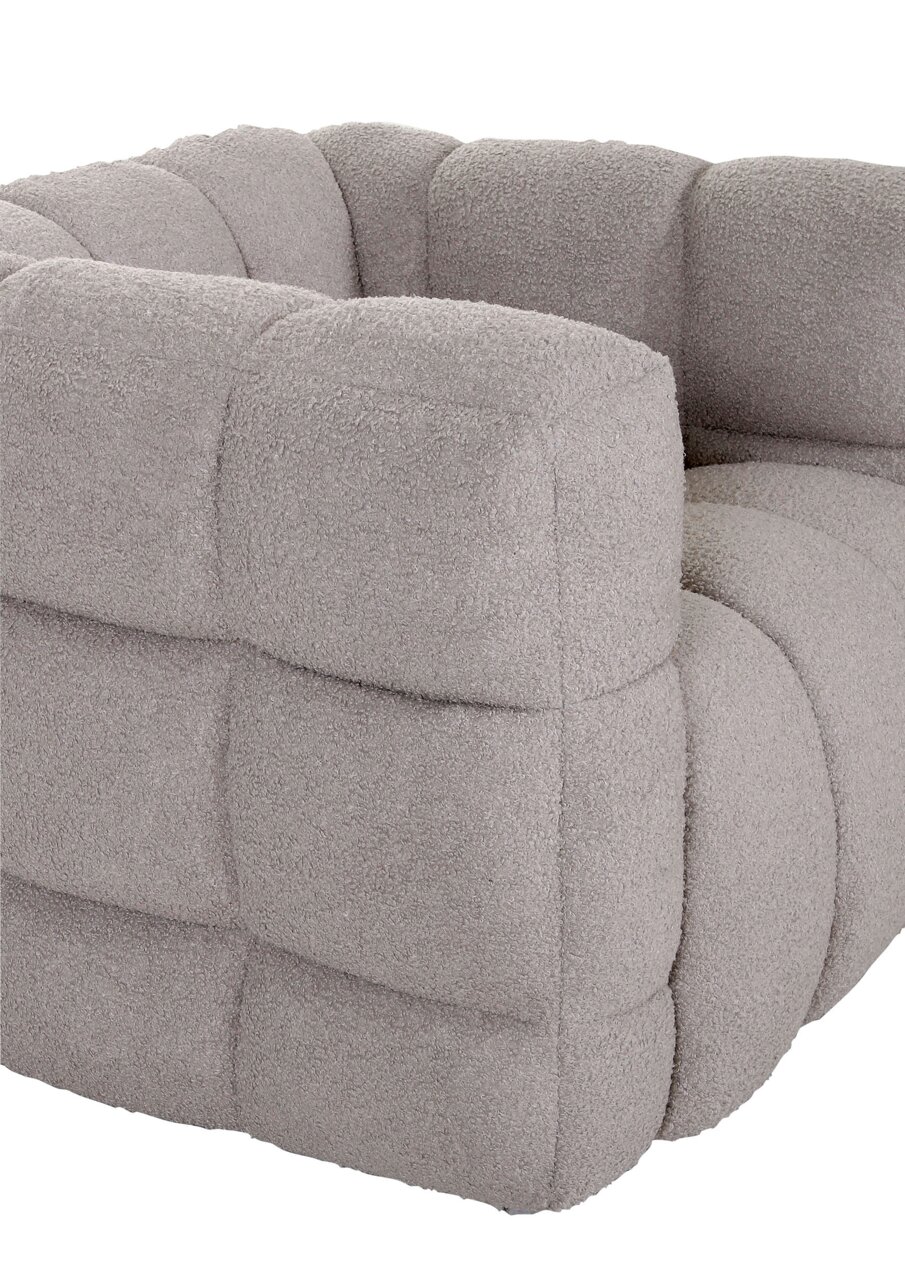 Nahaufnahme eines grauen, gepolsterten Drehsessels mit weicher Textur und quadratischem Muster, seitliche Perspektive.