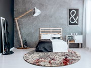 Moderner Designer-Teppich in einem stilvollen Schlafzimmer mit grauer Wand, Holzlampe und minimalistischen Möbeln, aus der Perspektive von vorne.