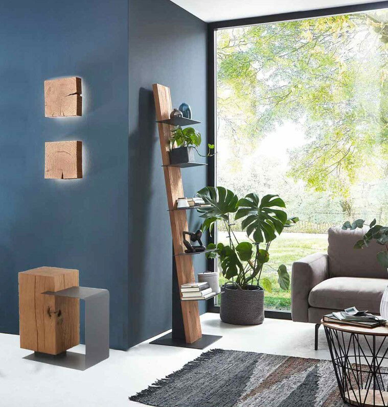 Modernes Wohnzimmer mit einem schrägen Standregal aus Holz und Metall, zwei rustikalen Wandleuchten aus Holz und einem Beistelltisch in einem hellen, luftigen Raum mit Blick auf den Garten.