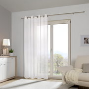 Weißer Ösenschal vor einem großen Fenster in einem modernen Wohnzimmer, seitliche Perspektive