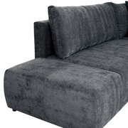 Graues Sofa mit weichem Stoffbezug, Ansicht von der Seite mit Fokus auf die Armlehne und Rückenkissen.