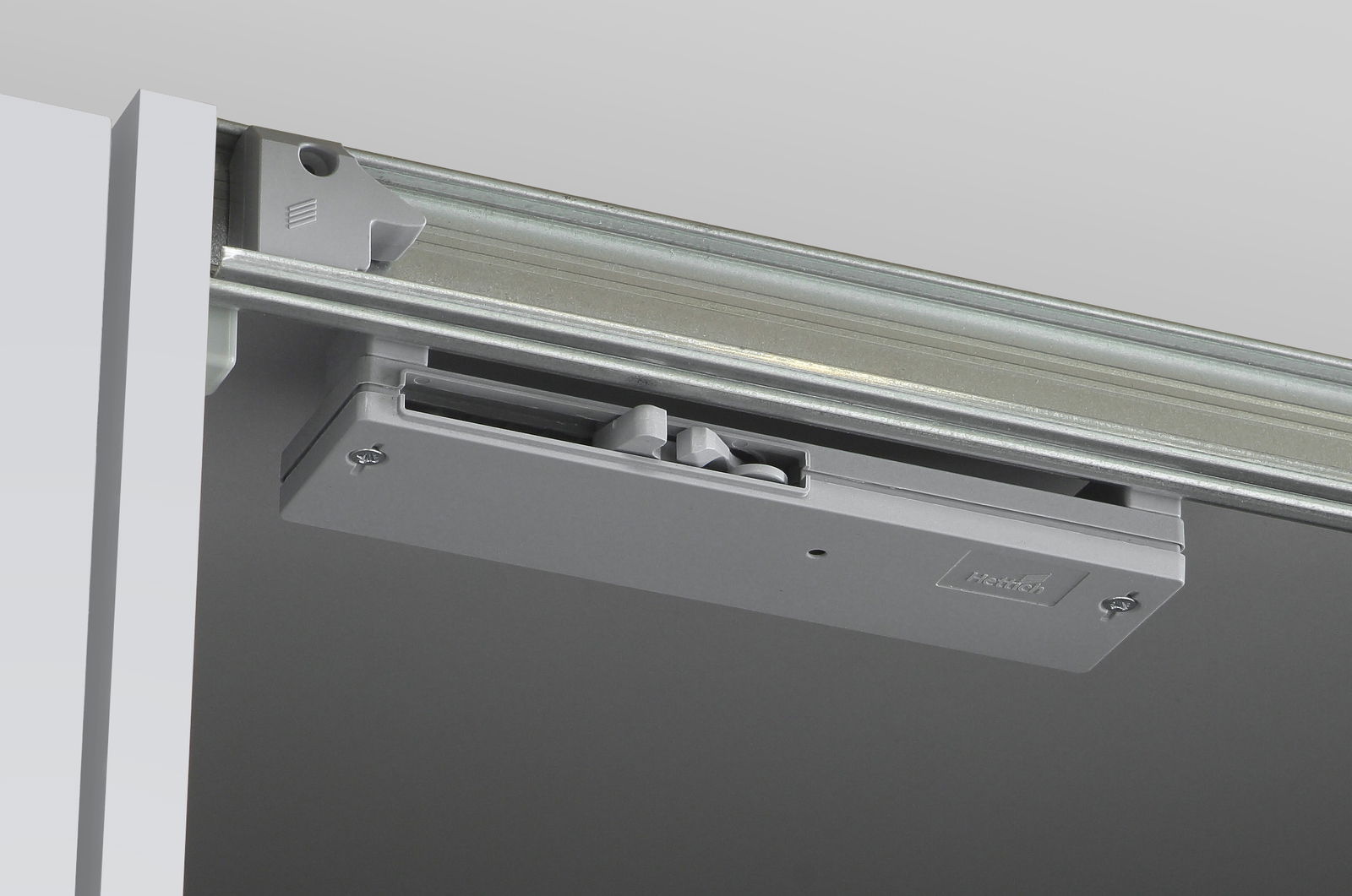 Nahaufnahme eines Schiebemechanismus für einen Dreh- und Schwebetürenschrank, von unten betrachtet.