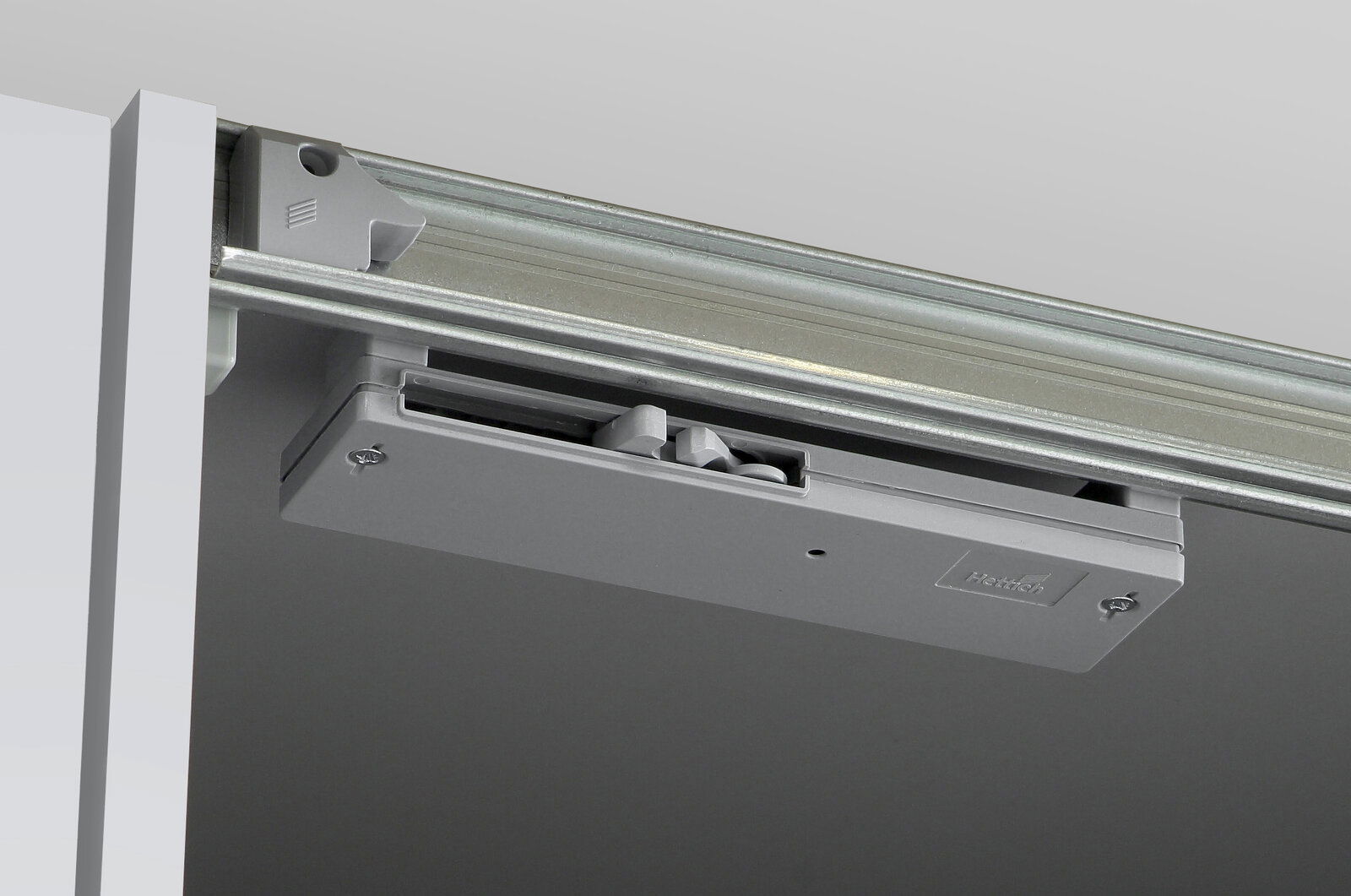 Nahaufnahme eines Schiebemechanismus für einen Dreh- und Schwebetürenschrank, von unten betrachtet.